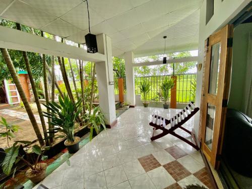 una sala de estar con un banco en una habitación con plantas en Green Villa, en Oluvil