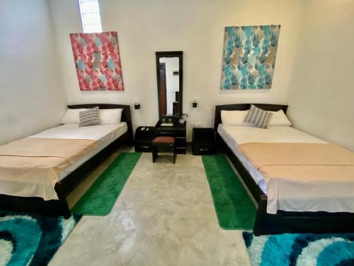 a room with two beds and a mirror at Green Villa in Oluvil