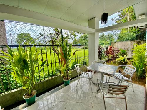 a patio with a table and chairs and plants at Green Villa in Oluvil