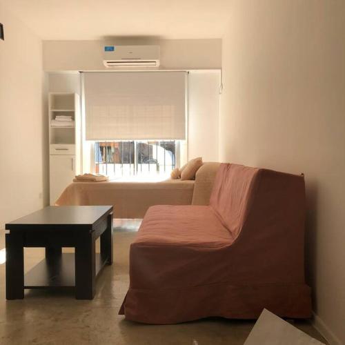 ein Wohnzimmer mit einem Sofa und einem Tisch in der Unterkunft Universo in Buenos Aires