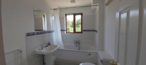 a bathroom with a sink and a tub and a toilet at Farmhouse: Beautiful rural location. London from 60 minutes. in Ashford