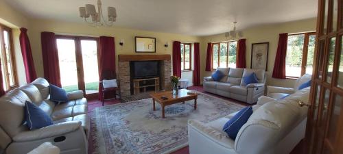 a living room with white couches and a fireplace at Farmhouse: Beautiful rural location. London from 60 minutes. in Ashford