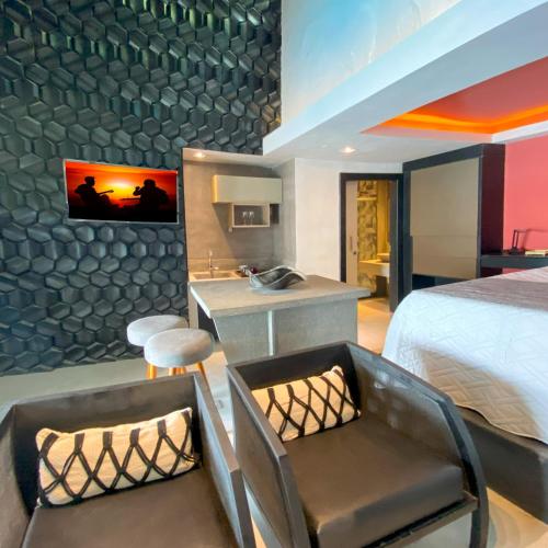 a hotel room with a bed and a desk and chairs at Rio Holiday Boutique Hotel in Niterói