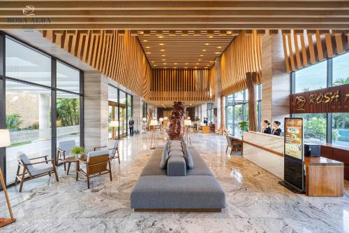 a lobby of a building with a couch in the middle at Rosa Alba Resort & Villas Tuy Hoa in Tuy Hoa
