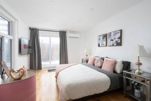 a bedroom with a large bed with pink pillows at Downtown Luxe: Metro, King Bed, Parking, Sleeps 6 in Montréal