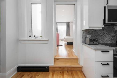 a kitchen with a door leading to a bedroom at Downtown Luxe: Metro, King Bed, Parking, Sleeps 6 in Montréal