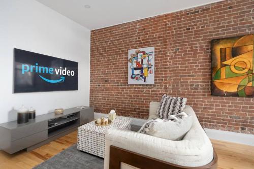 a living room with a couch and a brick wall at Downtown Luxe: Metro, King Bed, Parking, Sleeps 6 in Montréal