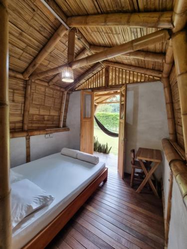 - une chambre avec un lit et du parquet dans l'établissement Pradera Ecoliving, à Betania