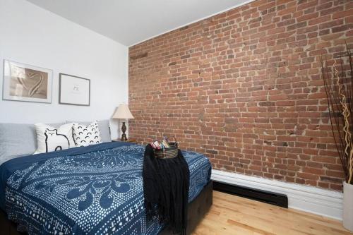 a bedroom with a brick wall and a bed at Downtown Luxe: Metro, King Bed, Parking, Sleeps 6 in Montréal