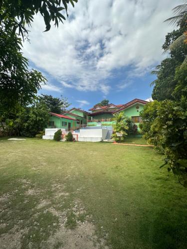 a house with a yard with green grass at DODS Apartelle in Looc