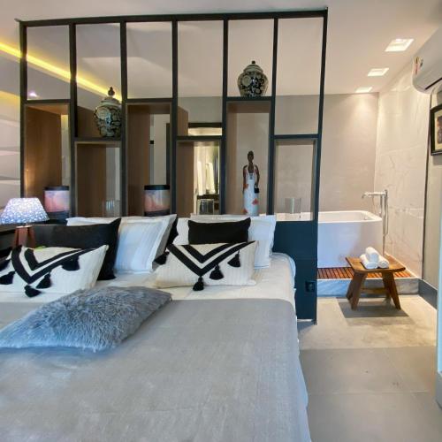 a bedroom with a large bed and a bath tub at Rio Holiday Boutique Hotel in Niterói