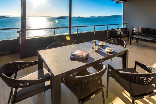 a table and chairs with a view of the ocean at Edge Apartments on Hamilton Island by HIHA in Hamilton Island