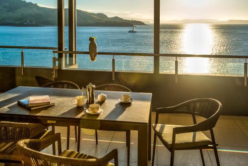 a table and chairs with a view of the water at Edge Apartments on Hamilton Island by HIHA in Hamilton Island