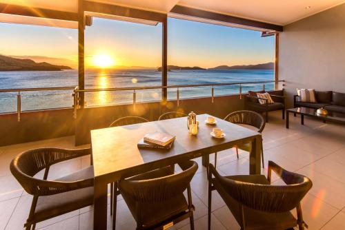 a restaurant with a table and chairs and a view of the ocean at Edge Apartments on Hamilton Island by HIHA in Hamilton Island