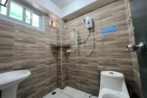 a bathroom with a shower with a toilet and a sink at Wanay's Rocky Mountain Homestay in Baguio