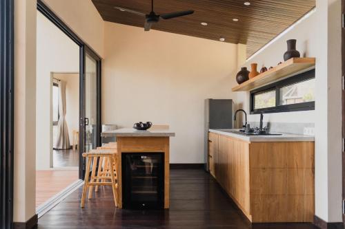 a kitchen with a wooden counter and a wooden table at DUNIA LOMBOK - Villas with Ocean View in Selong Belanak