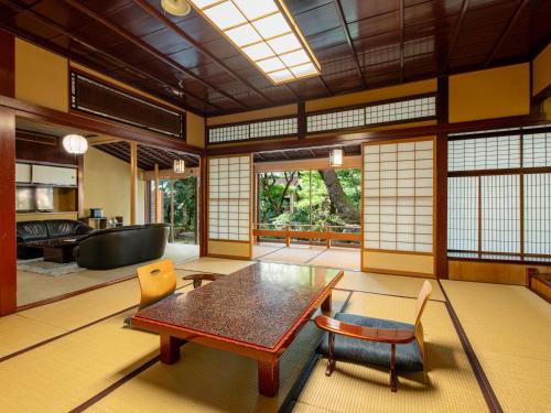 sala de estar con mesa de madera y sillas en Hoshi en Komatsu
