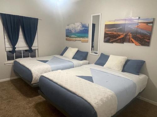 duas camas num quarto com azul e branco em New Listing!! Relax by the Beach!! 2 Queen Beds, 1 Sofa Couch, Free WiFi 2 TVs, Free Parking, Pool, Hot Tub, Gym , Elevator Accessible to property em Galveston