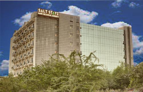 a large building with a sign on top of it at Saltstayz Premier - Golf Course Extension Road in Gurgaon