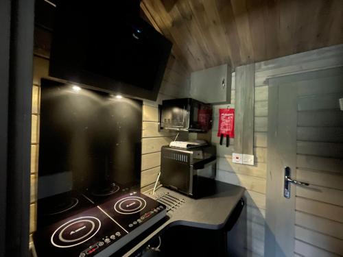 a small kitchen with a stove and a microwave at Daisy Cabin in Kincardine OʼNeil