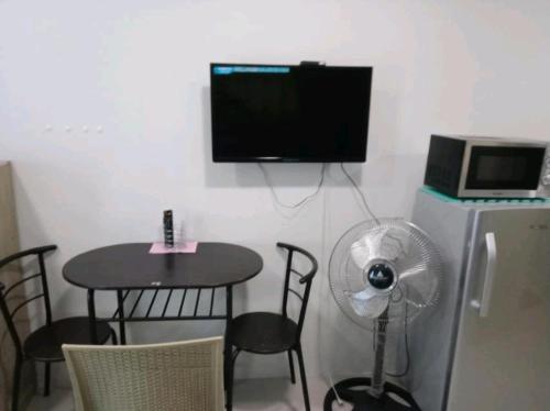 a room with a table and a fan and a tv at Jimi's Place in SMDC Katipunan Blue Residence in Manila