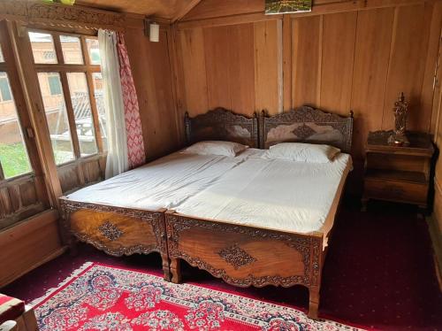 ein Schlafzimmer mit einem Holzbett in einem Zimmer mit einem Fenster in der Unterkunft New kolohai group of houseboats in Srinagar