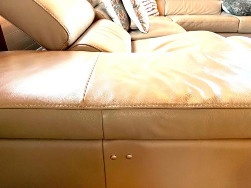 a brown leather ottoman in front of a couch at Gemütliches Chalet an bester Lage in Jona