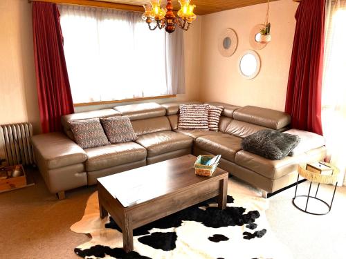 uma sala de estar com um sofá e uma mesa de centro em Gemütliches Chalet an bester Lage em Jona