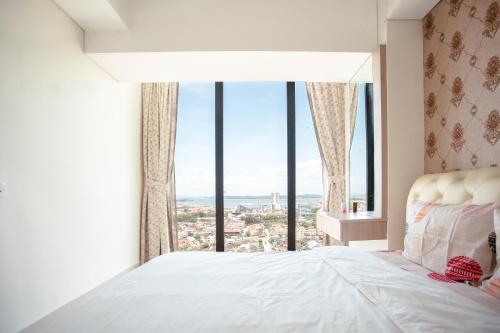 a bedroom with a bed with a large window at Palam Mansion at Meisterstadt Pollux Habibie Apartment in Batam Center