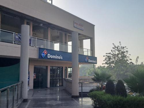 a building with a sign that reads domins at Gokul 2 BHK Entire Flat, Bharat City, Teela Mod, Nr Hindon Airport ,Bhopura , Ghaziabad in Ghaziabad