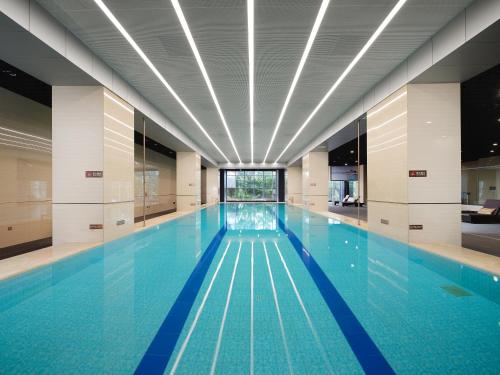 a swimming pool with blue water in a building at Crowne Plaza Dujiangyan, an IHG Hotel in Dujiangyan
