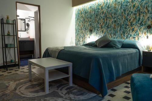 een slaapkamer met een bed met een blauwe deken en een tafel bij Polanco - Suite 2 de Lujo en Nápoles Cama King Size in Mexico-Stad