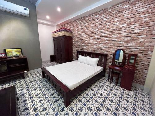 ein Schlafzimmer mit einem Bett und einer Ziegelwand in der Unterkunft Vungtau Surf Hostel in Vũng Tàu