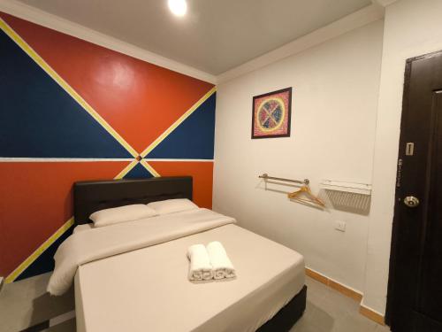 una camera da letto con un letto e due asciugamani di OYO 90876 Yss Homestead a Perai