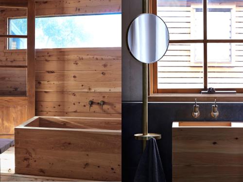 a wooden bathroom with a tub and a mirror at Ross Farm - Cabin in Meeniyan