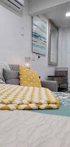 a bed with a yellow and white blanket on it at Eleg Stu Apt with Lux amnts steps frm Nautical Mile in Freeport