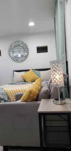 a living room with a couch and a table with a lamp at Eleg Stu Apt with Lux amnts steps frm Nautical Mile in Freeport