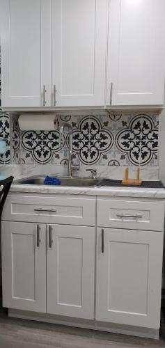 a kitchen with white cabinets and a sink at Eleg Stu Apt with Lux amnts steps frm Nautical Mile in Freeport