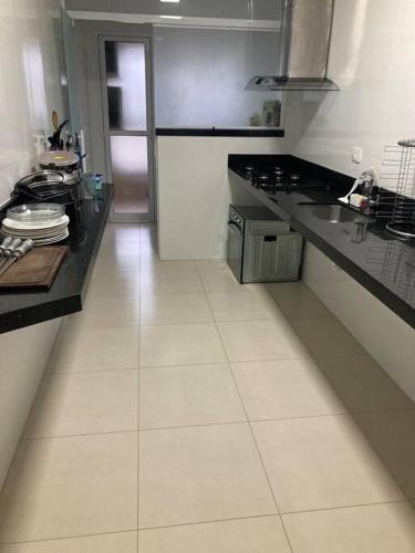 - une cuisine avec un comptoir et une cuisinière four supérieur dans l'établissement Belíssimo apartamento com vista praia, à Praia Grande