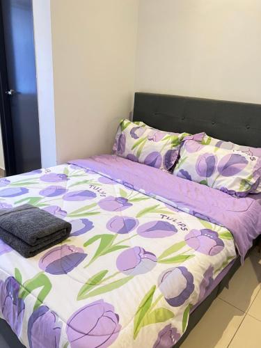 łóżko z fioletowo-białą kołdrą i poduszkami w obiekcie KLIA SomeHouse Homestay w mieście Banting