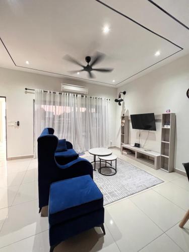 ein Wohnzimmer mit blauen Stühlen und einem TV in der Unterkunft KLIA SomeHouse Homestay in Banting