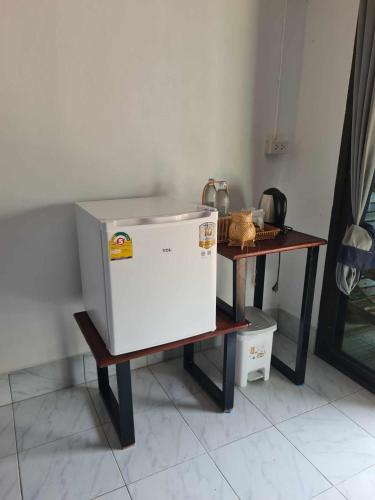 a refrigerator sitting on a table next to a table at Sunrise House in Ko Yao Noi