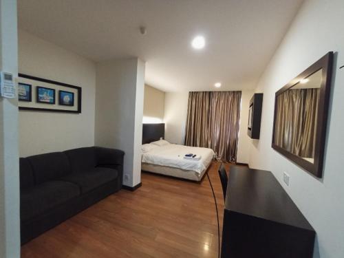 sala de estar con cama y sofá en H-5 INN, en Bintulu