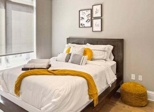 a bedroom with a large white bed with yellow blankets at Serenity In The City in Atlanta