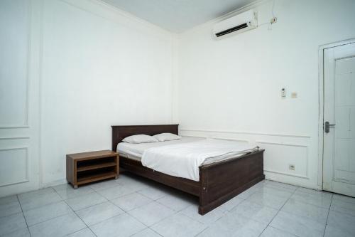 ein Schlafzimmer mit einem Bett und einem Nachttisch neben in der Unterkunft KS Hotel in Cilacap