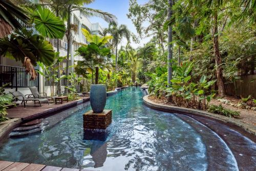 einen Pool in einem Resort mit einem Brunnen in der Unterkunft Private Ground Floor Apartment Beach Club Palm Cove in Palm Cove