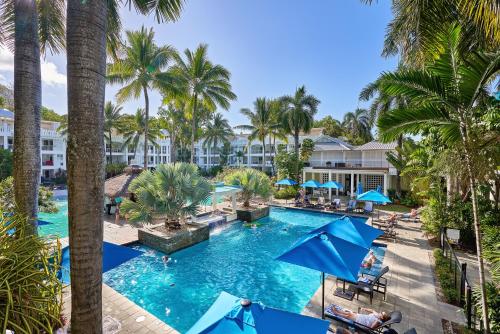 einen Luftblick auf einen Pool mit Palmen des Resorts in der Unterkunft Private Ground Floor Apartment Beach Club Palm Cove in Palm Cove