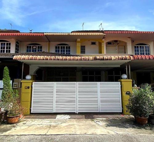 a house with a white gate in front of it at CozyHouse 4ROOM 4BATH ROOM 8PAX@Near BM Icon city in Bukit Mertajam