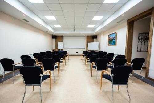 an empty room with chairs and a whiteboard at Hotel Dastan Aktobe in Aktobe