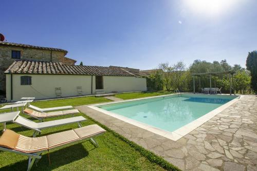 una piscina en un patio con sillas y una casa en La Palazzina - Happy Rentals, en Monteroni dʼArbia